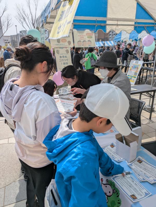 小学生がクイズに答えを書こうとしている写真