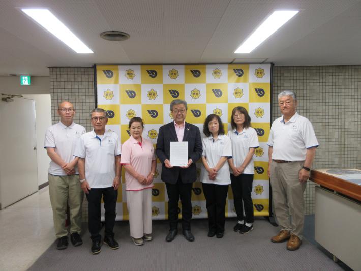 市長を中心にパネルの前で写真を撮っている様子