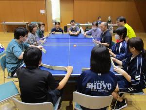 障がい者のかたと体験参加者が卓球バレーをしている様子