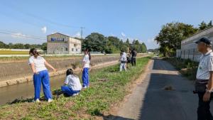 体験参加者が完成した土団子を川に投げ入れている様子