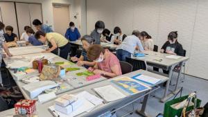 体験参加者が布絵本の作りかたの説明を聞いている様子