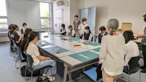 体験参加者が栞の作りかたの説明を受ける様子