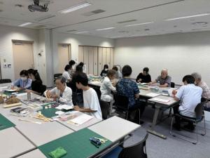 体験参加者が本の修理について説明を受けている様子