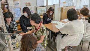 一日目に参加した体験参加者が音読の機械操作の説明を受けている様子