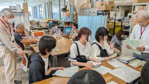 2日目の体験参加者が点字を読む体験をしている様子