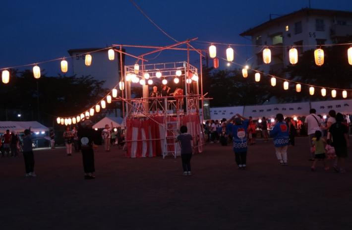 井野団地夏祭り盆踊りの写真。やぐらの周りに多くの人が集まっている。
