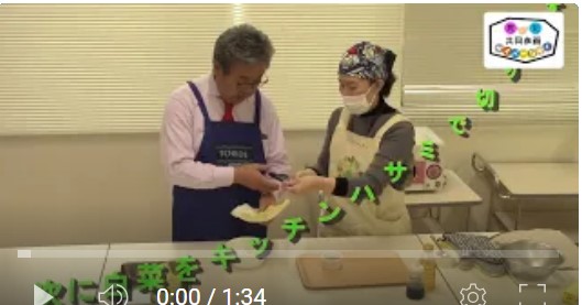 男性と女性が白菜をキッチンばさみで切っている。市長料理動画の切り抜き（レンチン白菜お浸し）