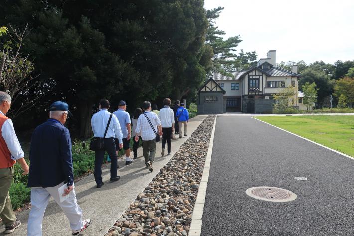 前田建設工業株式会社のICI総合センター内を旧渡辺甚吉邸に向かって徒歩で移動する参加者たちの様子