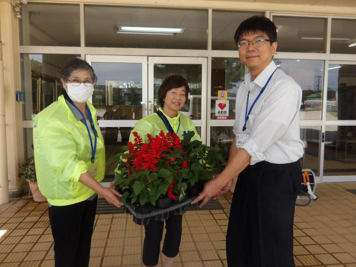 戸頭小学校にてお礼の花苗を先生に渡す人権擁護委員