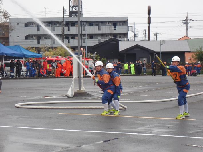 指揮者と1番員が筒先を交代している様子