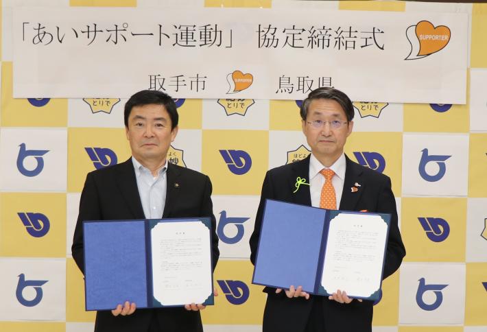 藤井市長と平井鳥取県知事が協定書を持ち並んで立っている写真