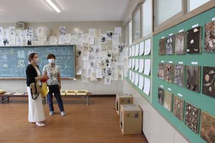 教室の壁に掲げられた作品を2人の女性が鑑賞している