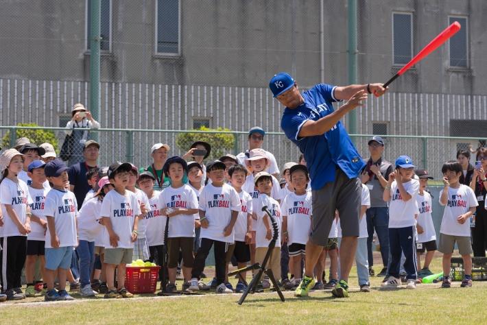 マック鈴木選手が子どもたちの前で素振りをしている