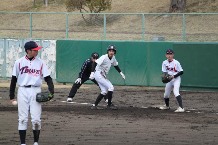永山クラブの選手が一塁にいて、取手クラブのピッチャーが牽制しています。